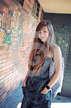 Beautiful young woman posing by graffiti wall