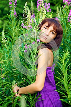 Beautiful young woman posing in green grass