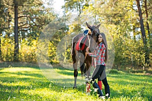 Beautiful young woman posing with a horse outdoor