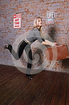 Beautiful young woman posing near brick wall