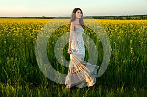 Beautiful young woman posing in rapseed field