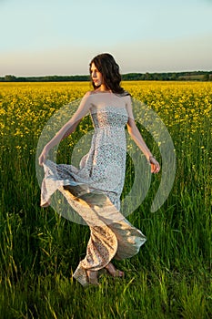 Beautiful young woman posing in rapseed field