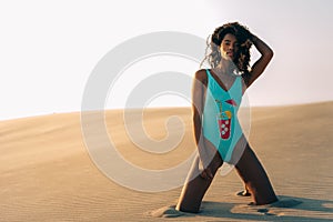 Beautiful young woman posing on the sand in a desert dunes