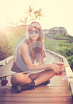 Beautiful young woman posing with a skateboard photo