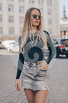 Beautiful young woman posing in the street, wearing sunglasses. Fashion summer photo photo