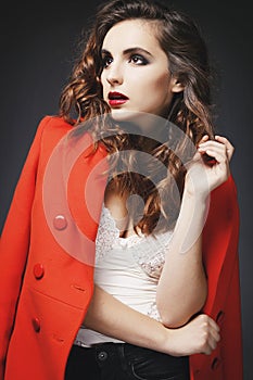 Beautiful young woman posing in studio over grey background. Fashion concept.