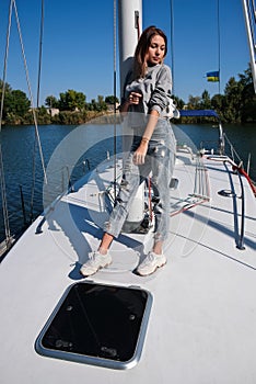 Beautiful young woman posing on yacht. Model is sailing on board