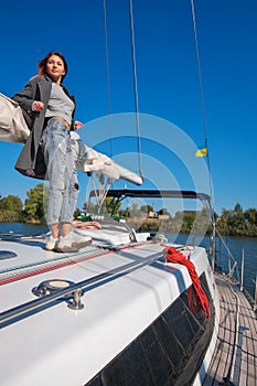 Beautiful young woman posing on yacht. Model is sailing on board