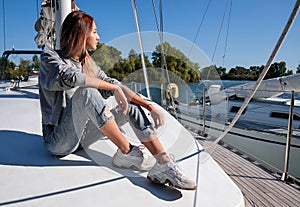 Beautiful young woman posing on yacht. Model is sailing on board