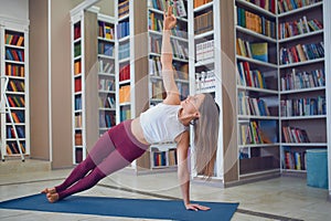 Beautiful young woman practices yoga asana Beautiful young woman practices yoga asana Vasishthasana - side plank pose in