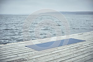 Beautiful young woman practices yoga asana Purvottanasana Upward Plank Pose on the wooden deck near the lake