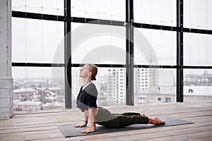 Beautiful young woman practices yoga asana Urdhva Mukha Svanasana - upward facing dog at the yoga class