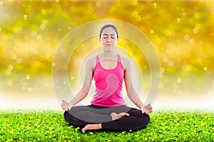 Beautiful young woman practicing yoga, sitting in a lotus position