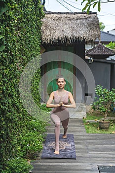 beautiful young woman practicing yoga in Warrior I with Prayer Hands pose