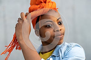 Beautiful young woman putting on headscarf