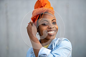 Beautiful young woman putting on headscarf