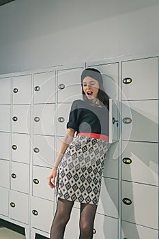 Beautiful young woman putting her arm in a locker