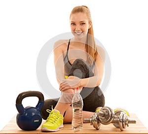 Beautiful young woman ready to workout with kettle and dumbbells