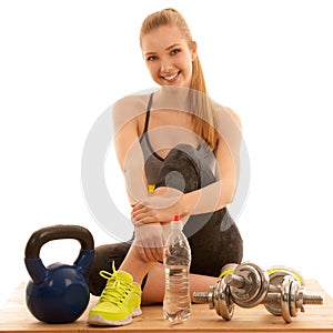 Beautiful young woman ready to workout with kettle and dumbbells