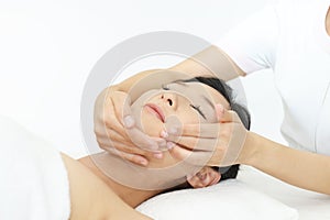 Beautiful young woman receiving facial massage