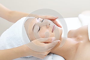 Beautiful young woman receiving facial massage