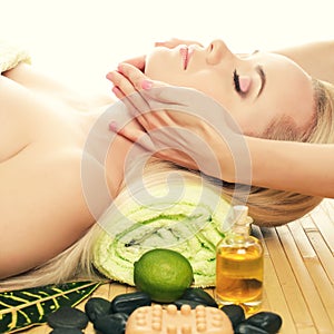 Beautiful young woman receiving facial massage at a spa salon