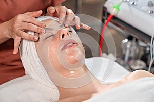 Beautiful young woman receiving head massage relaxing in spa salon