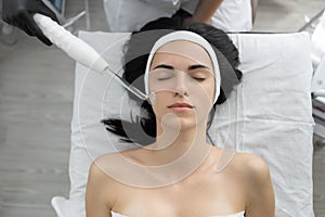 Beautiful young woman at the reception at the beautician, galvanic cleaning of the face using a current. Close-up