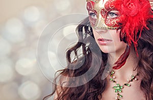 Beautiful young woman in a red carnival mask