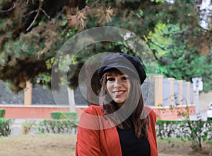 Beautiful young woman with red jacket and black cap