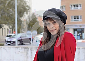 Beautiful young woman with red jacket and leather cap