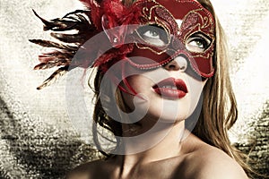 Beautiful young woman in a red mysterious mask