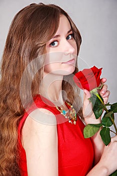 Beautiful young woman with a red rose