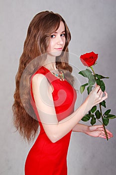 Beautiful young woman with a red rose