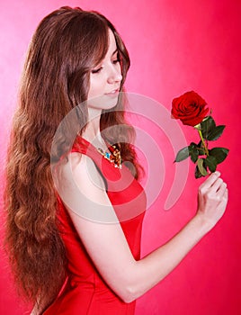 Beautiful young woman with a red rose