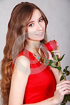 Beautiful young woman with a red rose