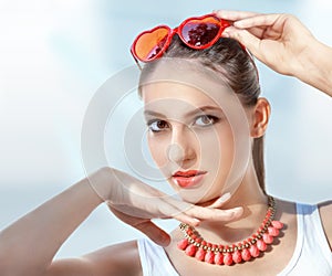 Beautiful young woman with red sunglasses