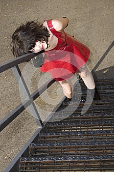 Beautiful Young Woman In Red Vinyl Dress On Fire Escape