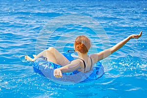 Beautiful young woman relax on inflatable ring in sea water