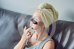 Beautiful young woman relaxing with face mask at home. Happy joy