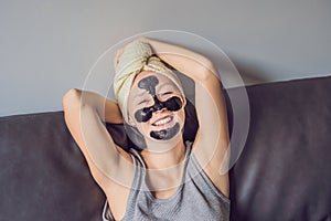 Beautiful young woman relaxing with face mask at home. Happy joy