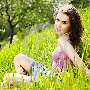 Beautiful young woman relaxing in the grass