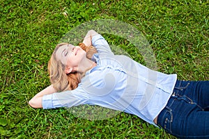 Beautiful young woman relaxing in grass