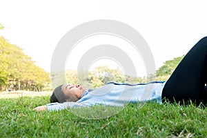 Beautiful young woman relaxing at the park,in green grass meadow