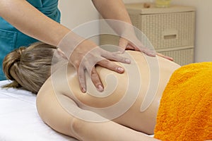 Beautiful young woman relaxing in spa salon. Relaxed woman lying down on massage bed during facial treatment at spa