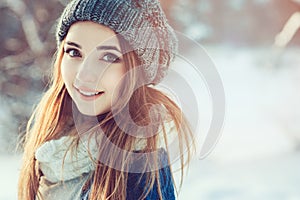 Beautiful young woman relaxing on winter walk in snowy forest, candid capture