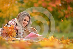 Beautiful young woman resting in autumnal park