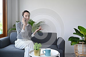 Beautiful woman resting on comfortable sofa and having cell phone conversation.