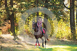 Beautiful young woman rides on a horse outdoor