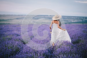 Beautiful young woman running in a lavender field